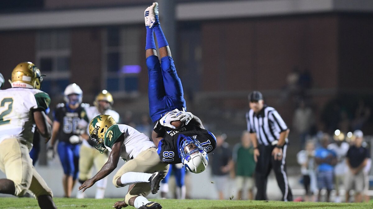 Brandon Cray (81) of Clayton catches a long pass and  flips through the air after being tackled by Jawuan Smith, center, of South Johnston. The South Johnston Trojans visited the Clayton Comets in a high school football game on October 5, 2018. Clayton won 26-14.