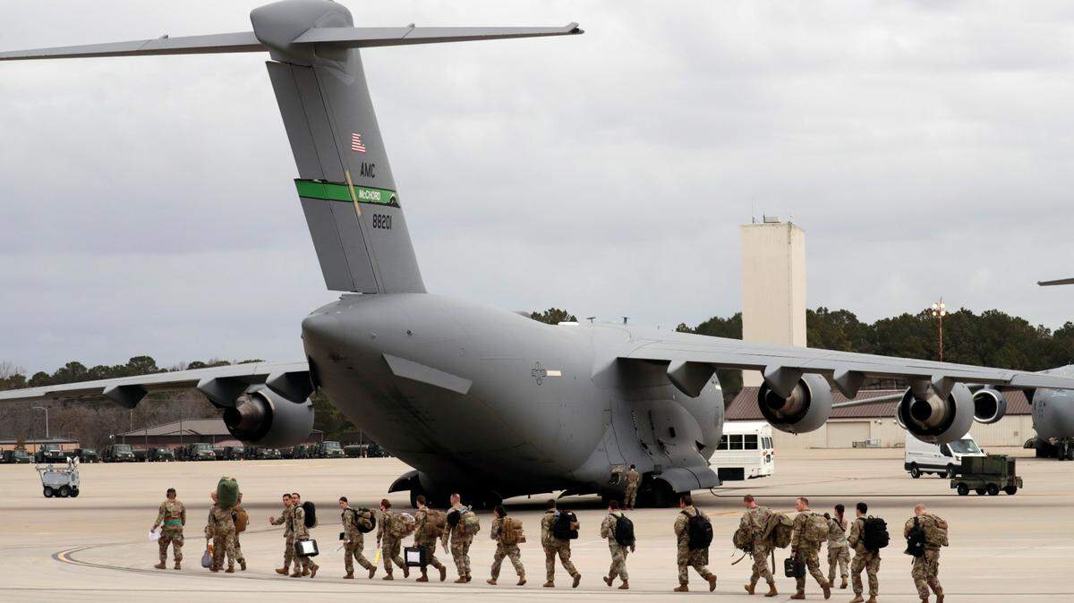 U.S. Army soldiers from the 18th Airborne Division walk out to a C-17 aircraft as they deploy to Europe on Thursday, Feb. 3, 2022 from Fort Bragg, N.C. President Joe Biden is ordering 2,000 U.S. troops to Poland and Germany amid the stalled talks with Russia over the Kremlin’s military buildup on Ukraine’s borders.