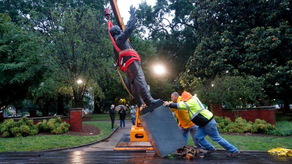 Workers with Carolina Stone Setting Company place the statue of Josephus Daniels onto a trailer after removing it from Raleighís Nash Square early Tuesday morning, June 16, 2020.