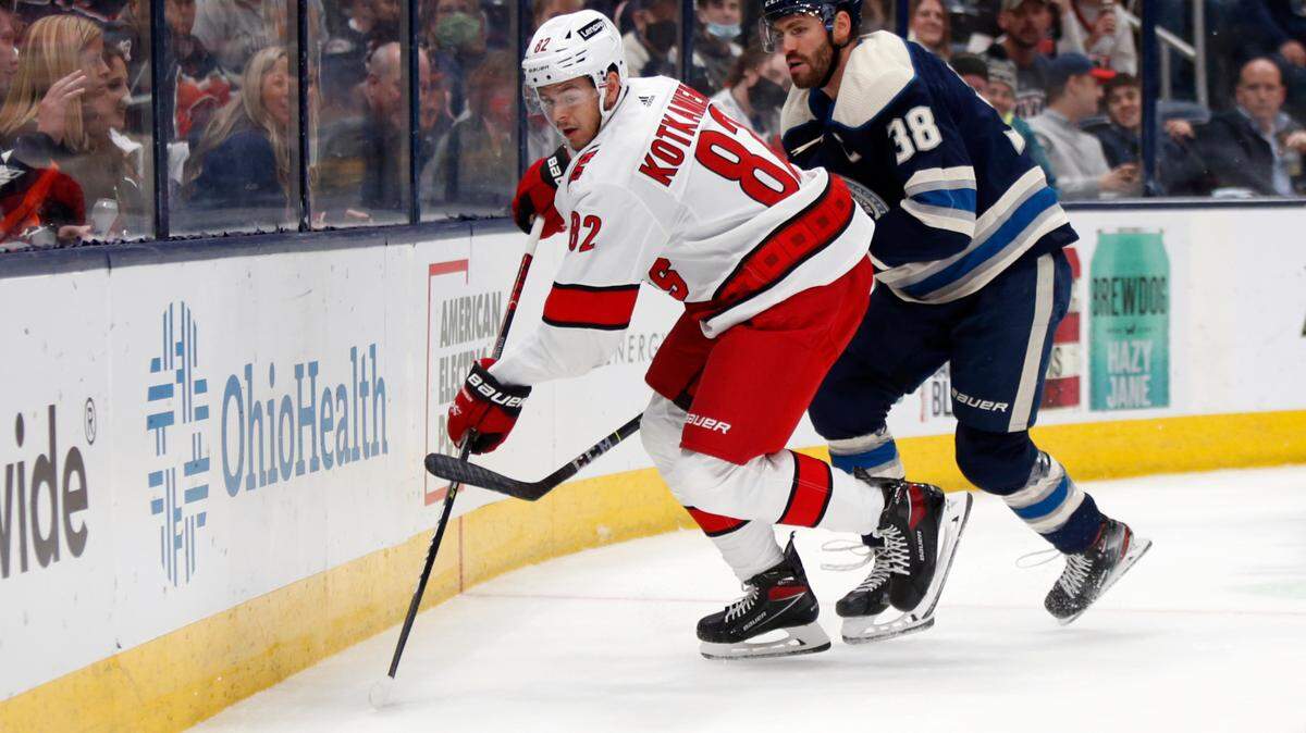 Carolina Hurricanes forward Jesperi Kotkaniemi, left, passes the puck in front of Columbus Blue Jackets forward Boone Jenner during an NHL hockey game in Columbus, Ohio, Saturday, Oct. 23, 2021. Carolina won 5-1. (AP Photo/Paul Vernon)