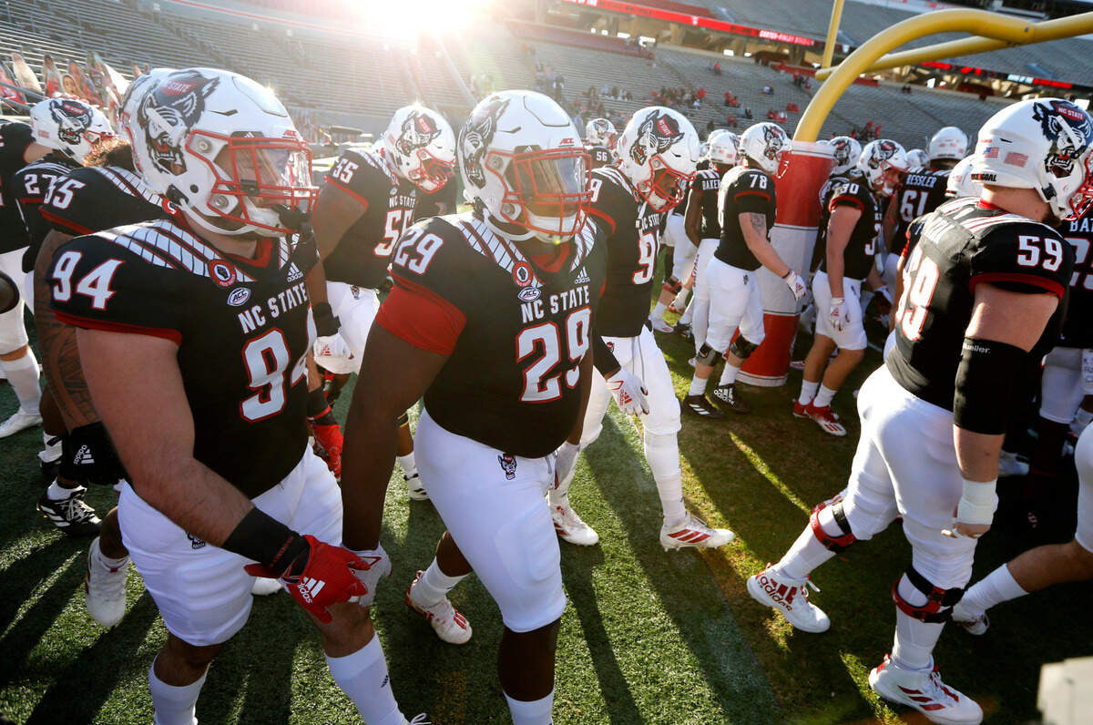 Players including N.C. State defensive tackle Alim McNeill (29) and defensive lineman Alec Neugent (94) head onto the field to warmup before N.C. State’s game against Georgia Tech at Carter-Finley Stadium in Raleigh, N.C., Saturday, Dec. 5, 2020.