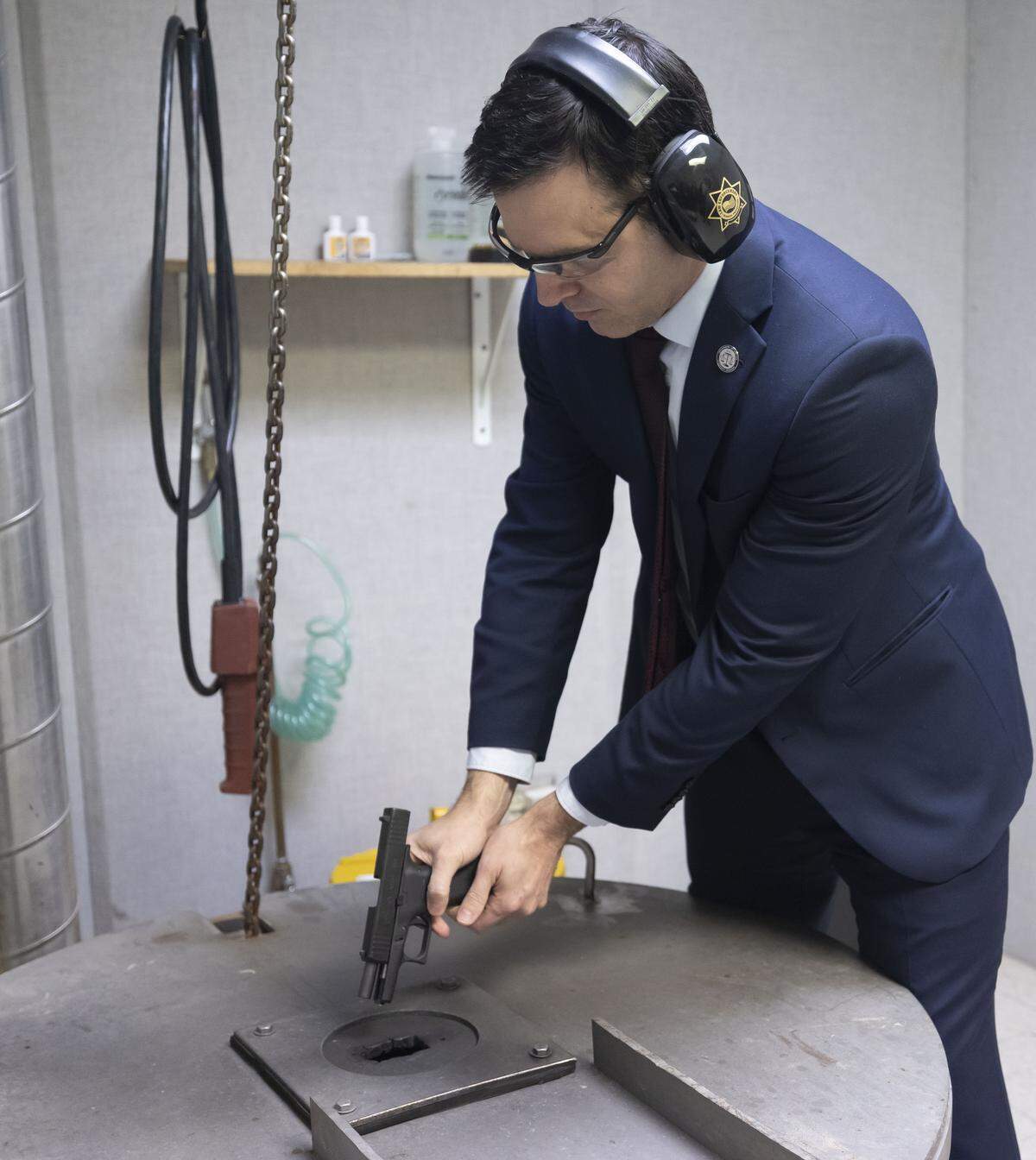 North Carolina Attorney General Jeff Jackson fires a pistol into a vertical shooting tank following a press briefing at the North Carolina State Bureau of Investigation on Tuesday, February 10, 2026 in Raleigh, N.C. 