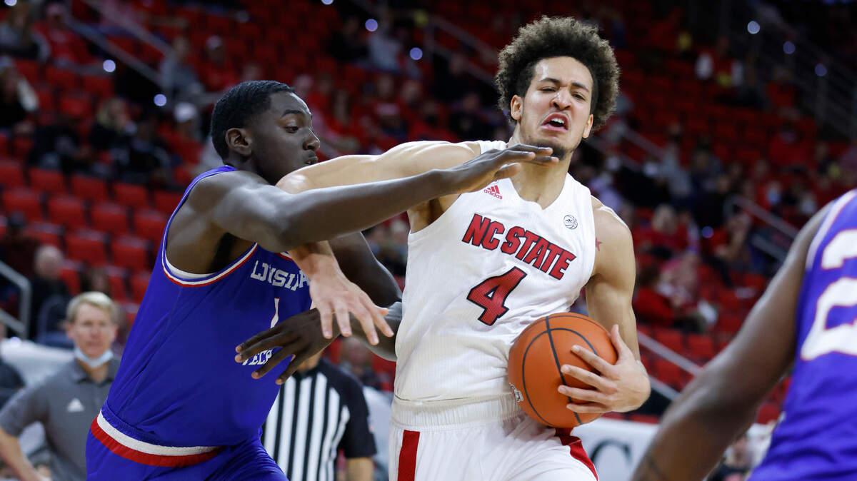 N.C. State’s Jericole Hellems (4) drives around Louisiana Tech’s Kenny Hunter (1) during the first half of N.C. State’s game against Louisiana Tech at PNC Arena in Raleigh, N.C., Saturday, November 27, 2021.