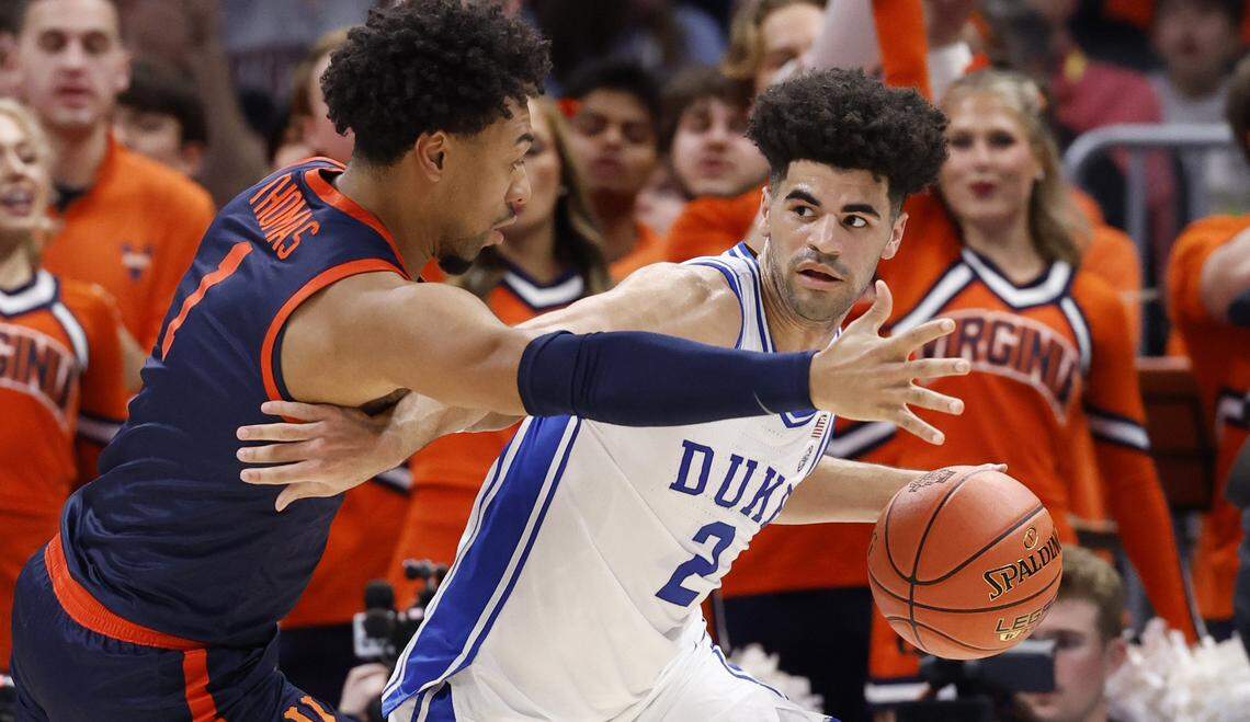 Duke’s Cayden Boozer (2) drives around Virginia's Malik Thomas (1) during the first half of Duke’s game against Virginia in the finals of the 2026 ACC Men’s Basketball Tournament at the Spectrum Center in Charlotte, N.C., Saturday, March 14, 2026.
