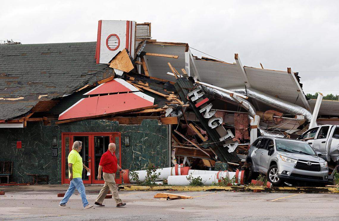 People walk past damage to Hing Ta Restaurant following a tornado in Rocky Mount, N.C. on Friday, Sept. 27, 2024.