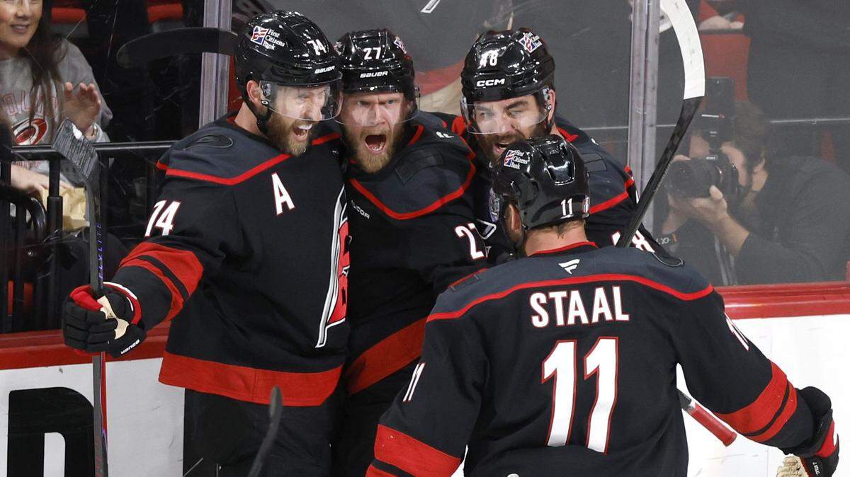 Carolina's Jaccob Slavin (74), Jordan Martinook (48), and Jordan Staal (11) celebrate with Nikolaj Ehlers (27) after he scored in the second period of the Hurricanes’ game against the Canadiens in game two of the Eastern Conference Finals at the Lenovo Center in Raleigh, N.C., Saturday, May 23, 2026.