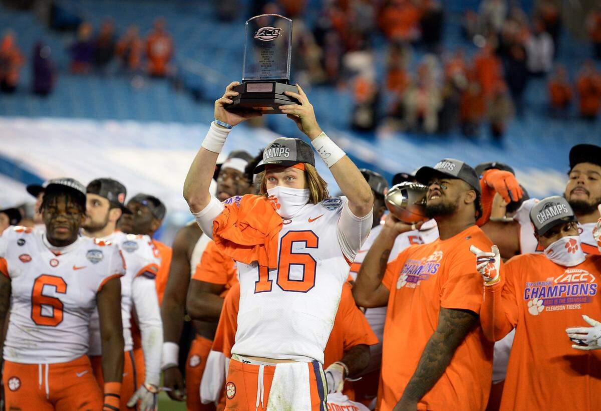 Clemson Tigers quarterback Trevor Lawrence holds the MVP trophy above his head following the teamÕs victory over Notre Dame in the ACC Championship game at Bank of America Stadium in Charlotte, NC on Saturday, December 19, 2020. The Tigers defeated the Fighting Irish 34-10.