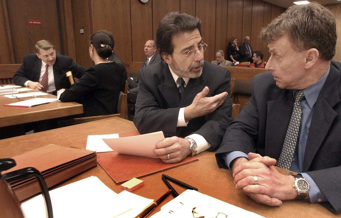 Defense attorney David Rudolf discusses strategy with Michael Peterson (at right) Monday morning as jury selection begins for his murder trial. Peterson has been accused of murdering his wife Kathleen in December of 2001. At left is Durham County District Attorney Jim Hardin conferring with his prosecuting team.
