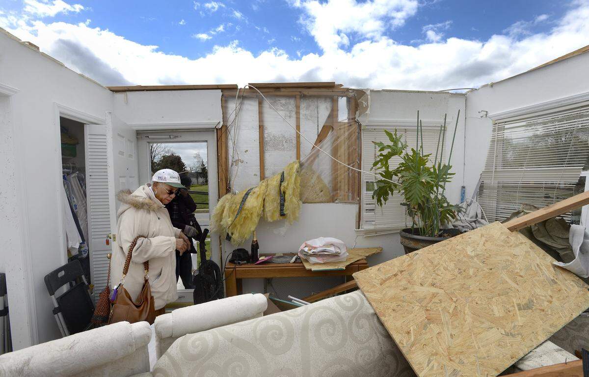Alva Gripper, 72, sorts through clothing in the remnants of her home in Greensboro, N.C. Monday, April 16, 2018. A tornado ripped through this eastern Greensboro neighborhood destroying dozens of homes. Gripper, who will now stay with the daughter said , "It's good, it's good...I'm fine, I'll just take it one day at a time and take it in stride." She was not at home when the storm hit.