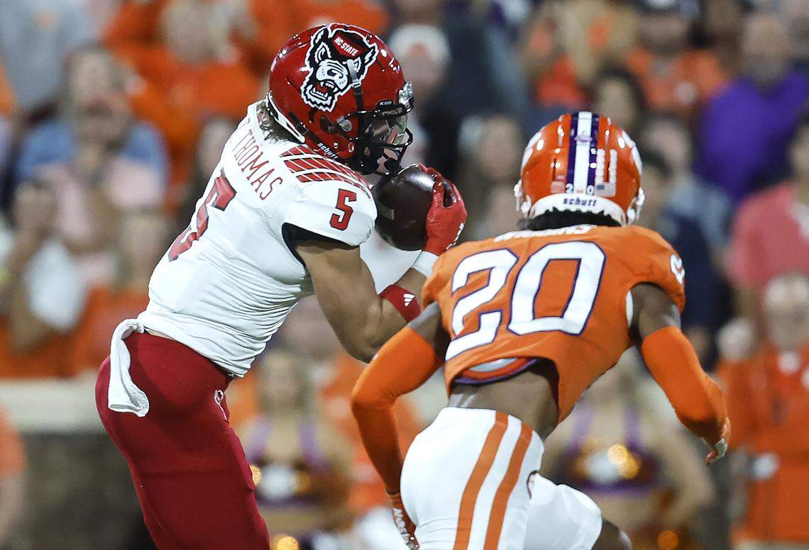 N.C. State wide receiver Thayer Thomas (5) pulls in a pass as Clemson cornerback Nate Wiggins (20) defends during the first half of N.C. State’s game against Clemson at Memorial Stadium in Clemson, S.C., Saturday, Oct. 1, 2022.