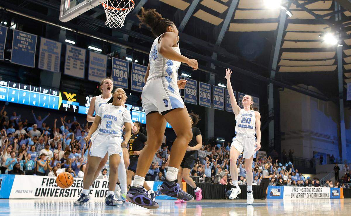 North Carolina’s Alyssa Ustby (1), Grace Townsend (2) and Lexi Donarski (20) celebrate after Indya Nivar (24) made the basket as time expired in the third quarter of UNC’s 58-47 victory over West Virginia in the second round of the NCAA women’s basketball tournament at Carmichael Arena in Chapel Hill, N.C., Monday, March 24, 2025.
