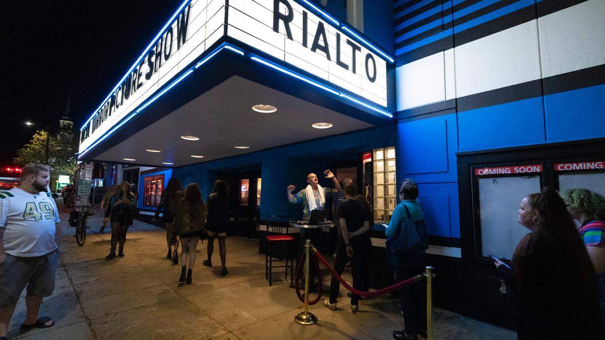 Hayes Permar yells to those in line to have their tickets cued up on their phone before a showing of “The Rocky Horror Picture Show” at the Rialto Theater in Raleigh on Oct. 27, 2023.