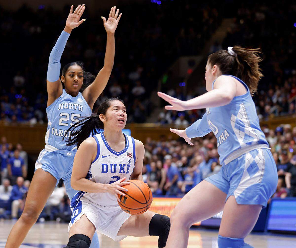Duke’s Vanessa de Jesus drives between North Carolina’s Deja Kelly and Eva Hodgson during the first half of the Tar Heels’ 45-41 win over Duke on Sunday, Feb. 26, 2023, at Cameron Indoor Stadium in Durham, N.C.