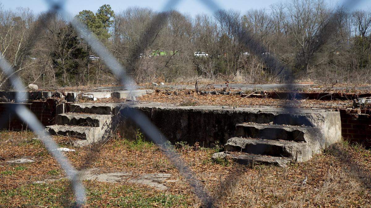 The crumbling foundations of former residences can be seen from outside the fence surrounding Fayette Place, the 22-acre former site of the Fayetteville St. Apartments in Durham.