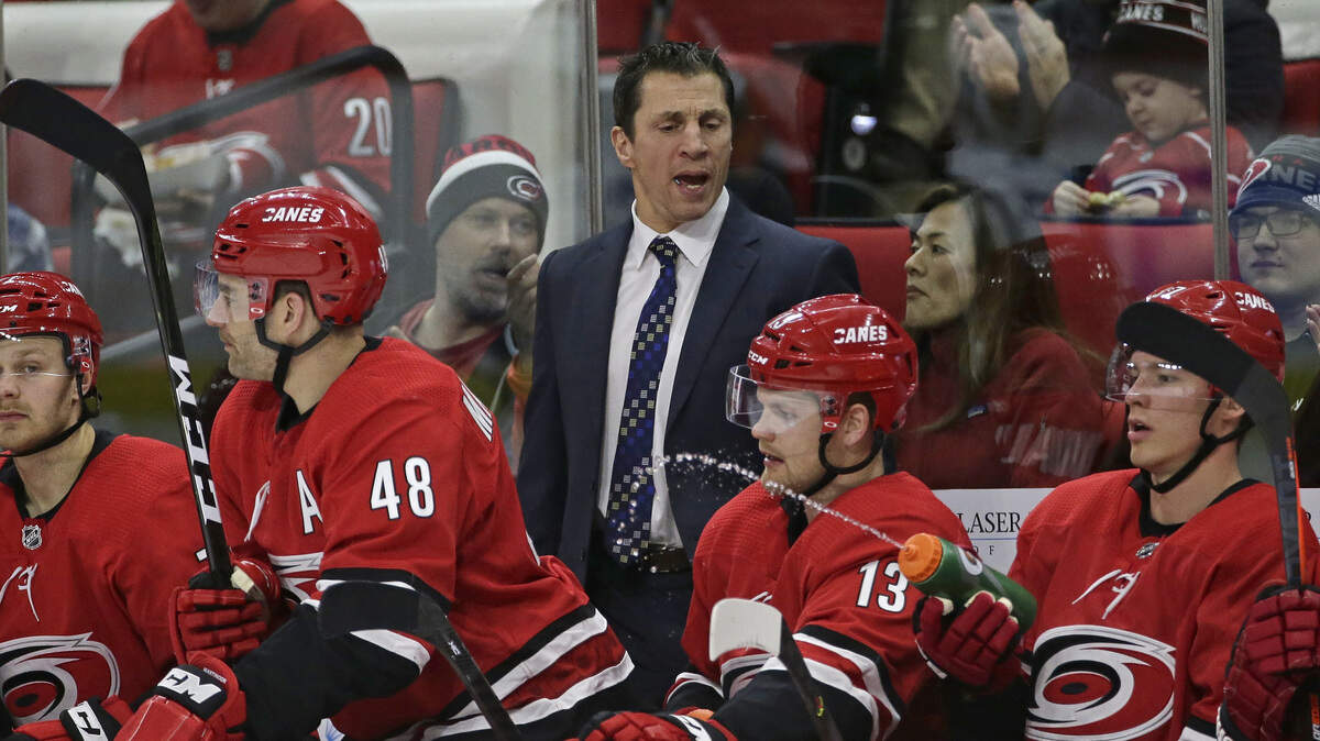 Carolina Hurricanes head coach Rod Brind’Amour, center top, speaks with players during the second period of an NHL hockey game against the Vancouver Canucks in Raleigh, N.C., Sunday, Feb. 2, 2020. (AP Photo/Gerry Broome)