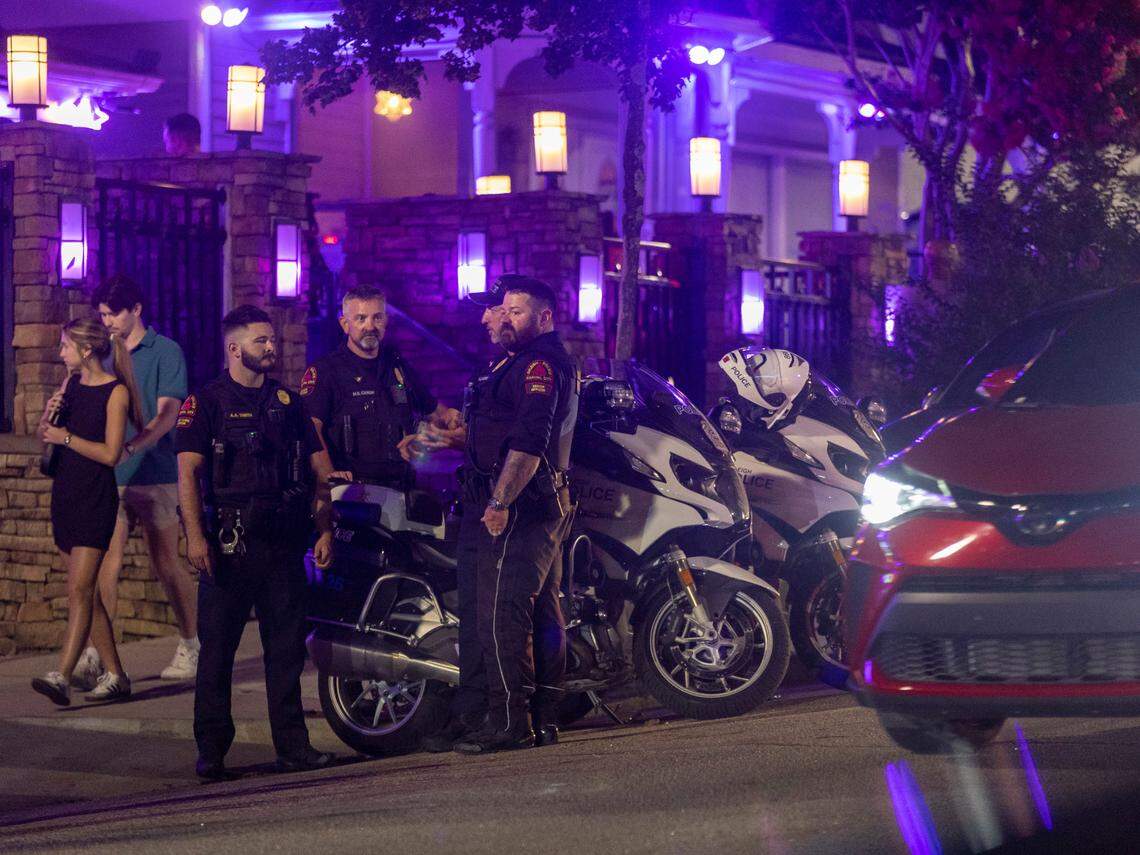 As midnight approaches four Raleigh Police Department motorcycle officers gather at the corner of Glenwood Avenue and Johnson Streets on Friday July 21, 2023 in Raleigh, N.C.