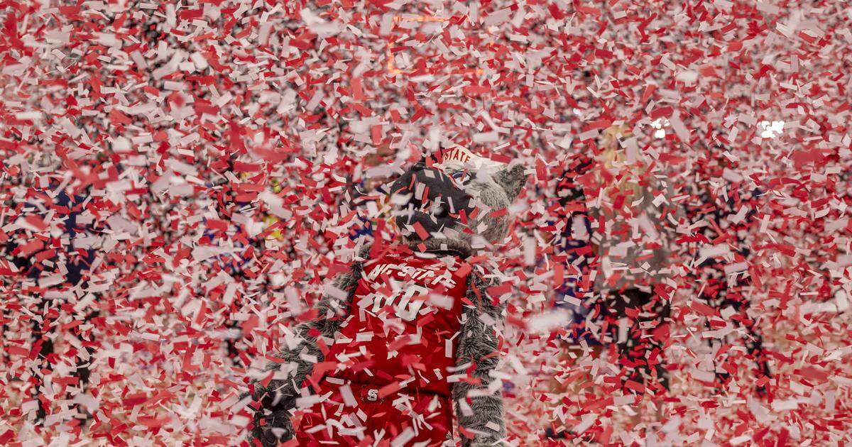 The N.C. State mascot Mr. Wolf is buried beneath a shower of confetti as they celebrate their 84-76 victory overt North Carolina to clinch the ACC Tournament Championship at Capitol One Arena on Saturday, March 16, 2024 in Washington, D.C.