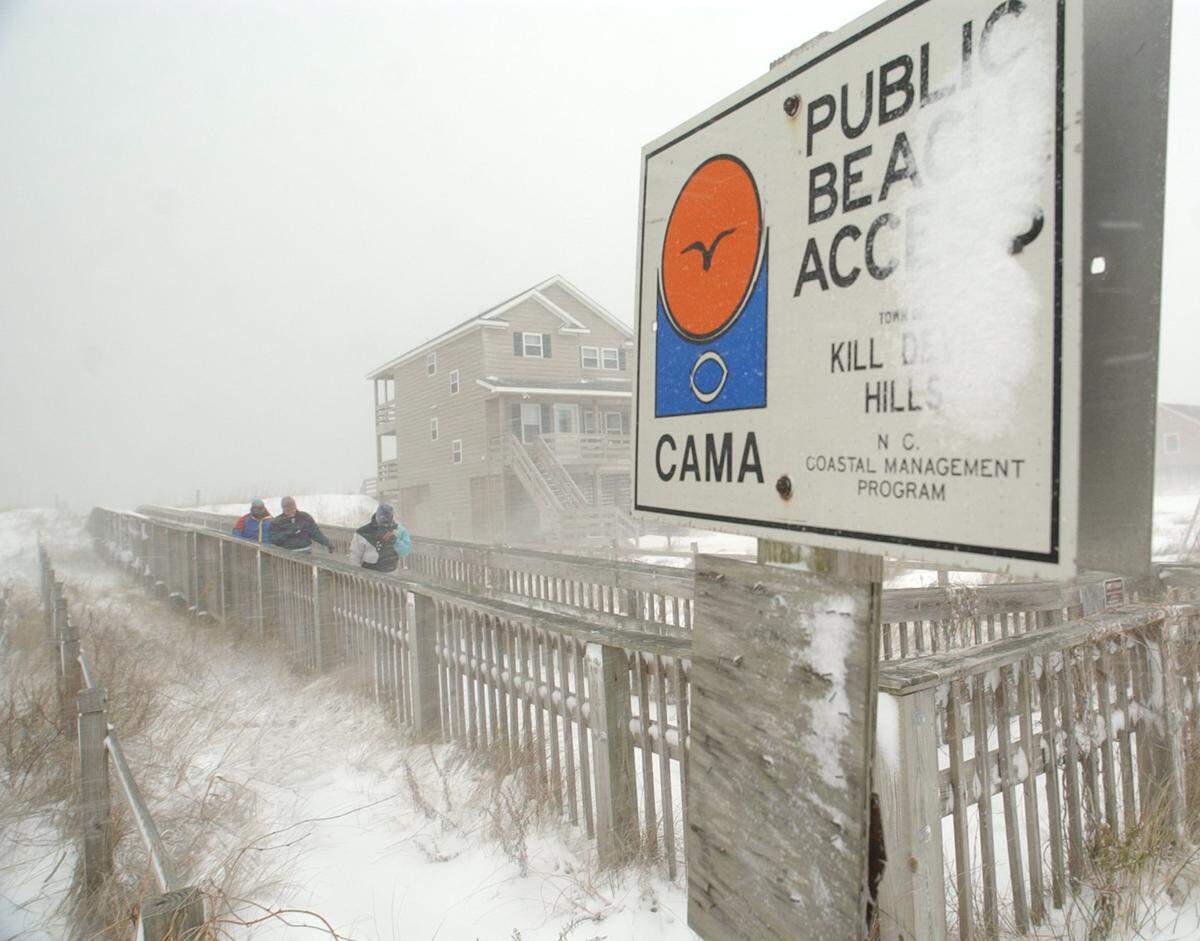 -This pubic beach access sing is covered with snow in Kill Devil Hills as a winter storm hits the area in January 2002.