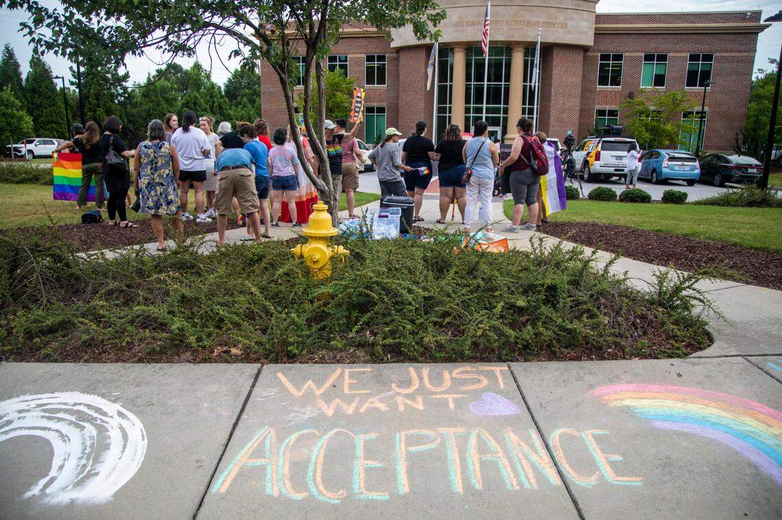 About 50 demonstrators rally outside the Holly Springs Law Enforcement Center to urge the town council to sign a Pride Month proclamation and adopt a non-discrimination ordinance. Holly Springs Mayor Sean Mayefskie refused to sign the proclamation. He said then that the town already has “diverse and inclusive” policies.