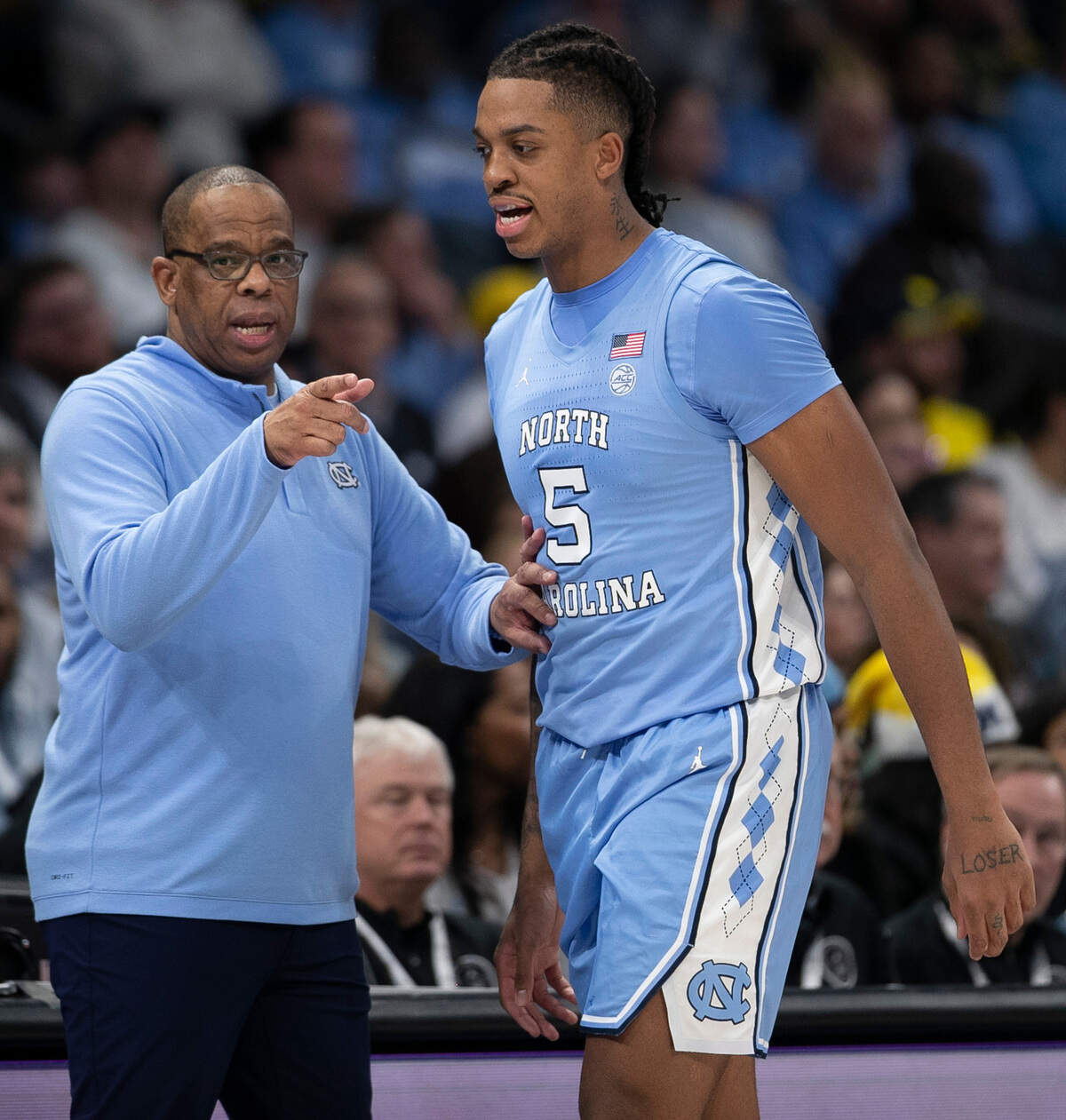 North Carolina coach Hubert Davis talks with Armando Bacot (5) in the second half against Michigan on Wednesday, December 21, 2022 at the Spectrum Center in Charlotte, N.C.