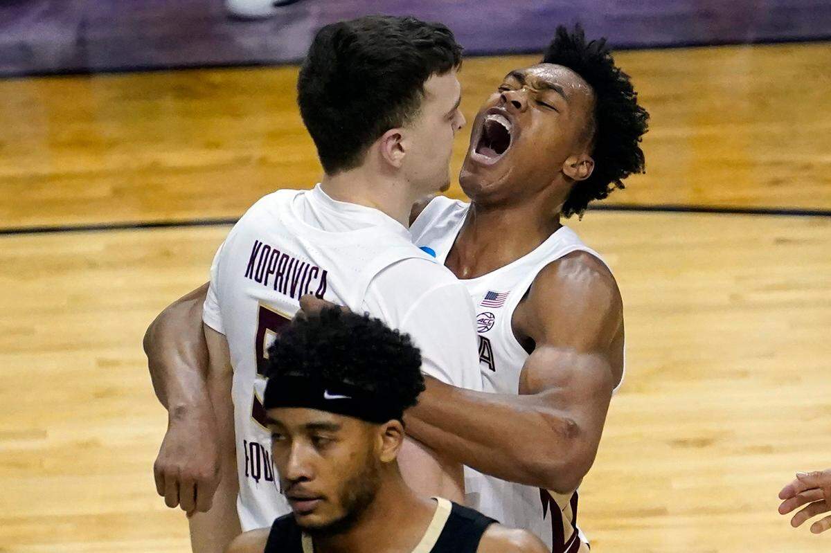 Florida State center Balsa Koprivica (5) gets a hug from teammate Scottie Barnes, right, after a dunk during the second half of a second-round game against Colorado in the NCAA college basketball tournament at Farmers Coliseum in Indianapolis, Monday, March 22, 2021. 