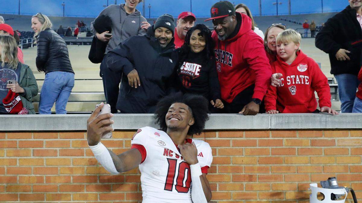 N.C. State’s KC Concepcion (10) takes photos with fans after the Wolfpack’s 26-6 victory over Wake Forest at Allegacy Stadium in Winston-Salem, N.C., Saturday, Nov. 11, 2023.