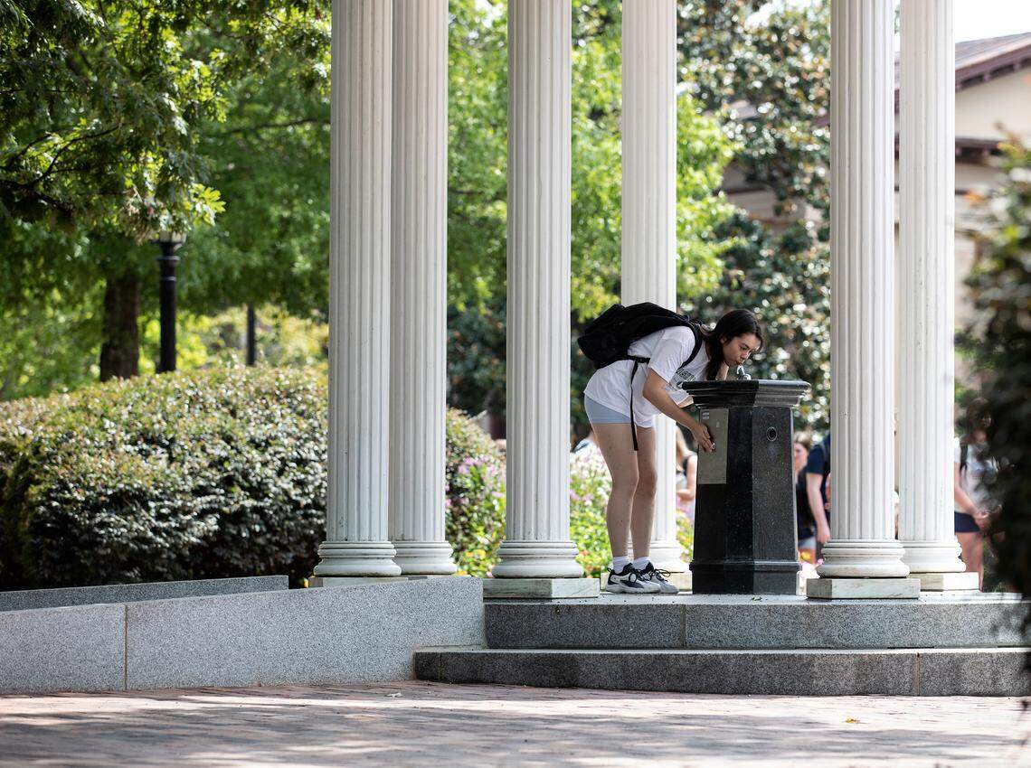 A person drinks from the Old Well on the first day of classes at UNC-Chapel Hill on Monday, Aug. 21, 2023. The university landmark underwent renovations this summer to improve accessibility, including the addition of a sloped ramp and a lowered drinking fountain. 