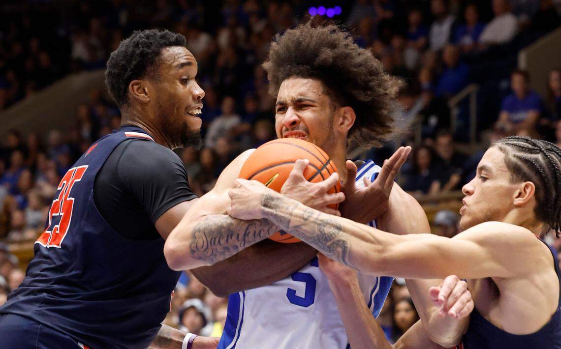 Duke’s Tyrese Proctor (5) drives between Lincoln’s Peter Sorber (25) and Freddie Young, Jr. (2) during the first half of Duke’s exhibition game against Lincoln (Pa) University at Cameron Indoor Stadium in Durham, N.C., Saturday, Oct. 19, 2024.