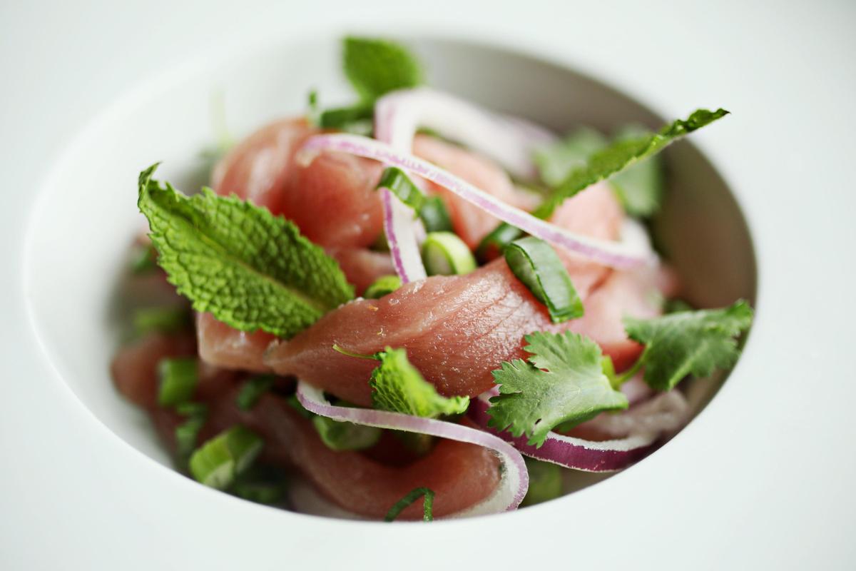 Raw tuna larb takes the form of sashimi-size pieces of the fish, entangled in a kaleidoscope of mint leaves, rings of red onion, and spangles of chopped scallion at Osha in Holly Springs.