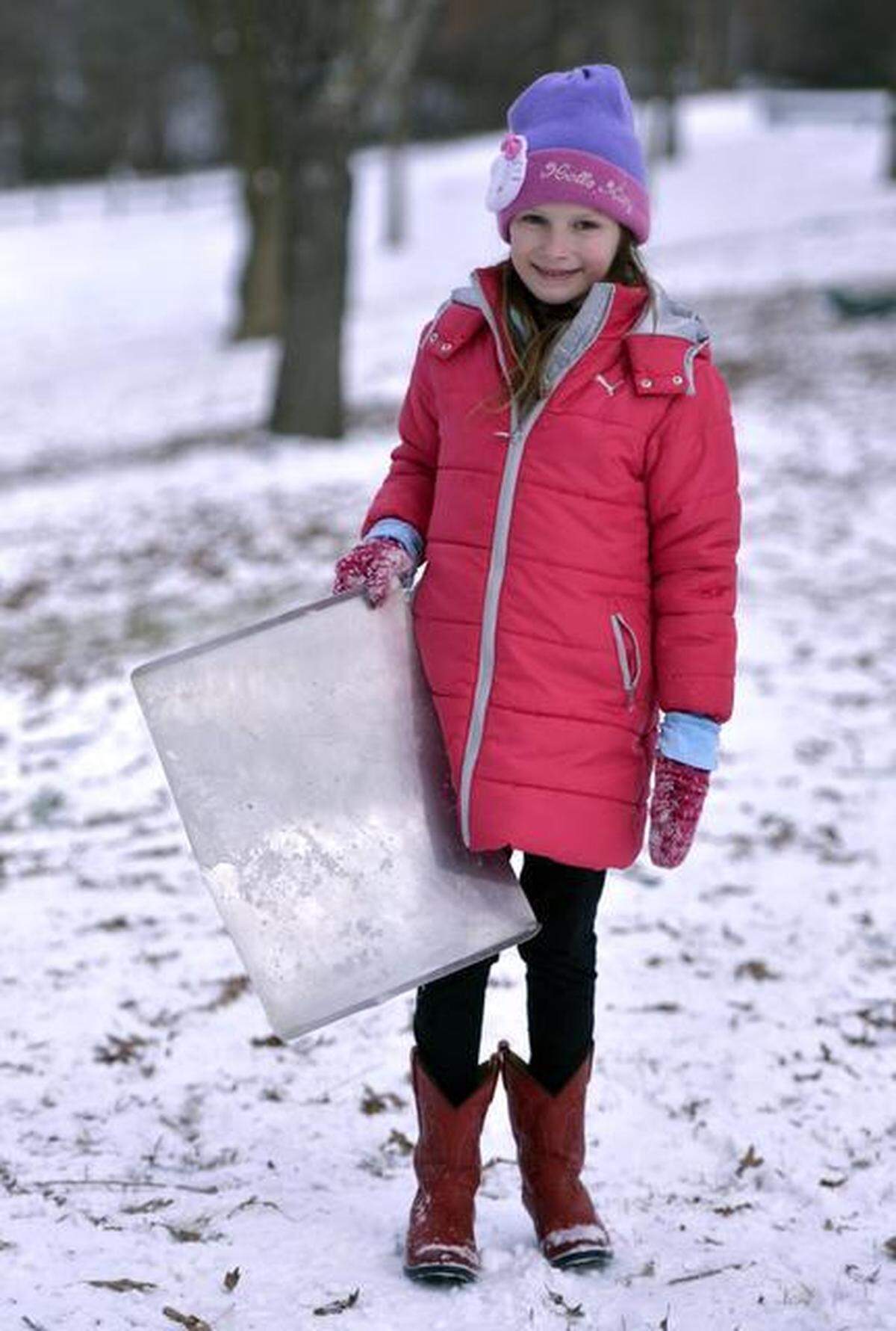 Marin Moore, 7, holds the metal cookie sheet she was using for an improvised sled at Dix Hill, Wednesday, January 29, 2014 in Raleigh.