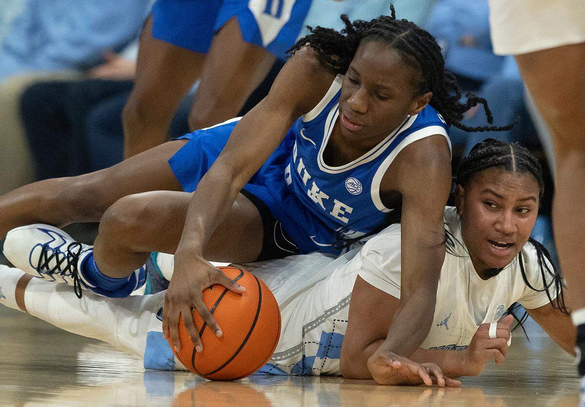Duke’s Jadyn Donovan and North Carolina’s Reniya Kelly dive on the floor during the first half of the Tar Heels’ 53-46 overtime win on Thursday, Jan. 9, 2025, at Carmichael Arena in Chapel Hill, N.C.