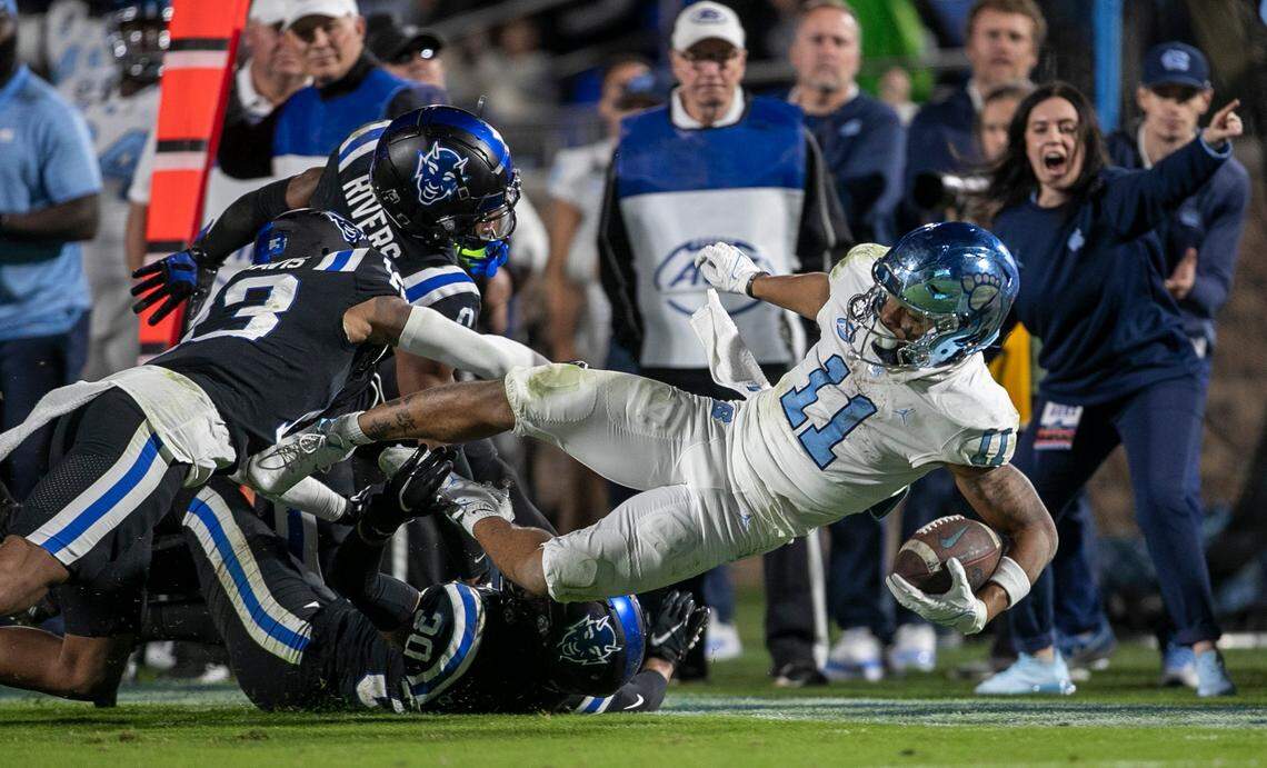 Duke’s Tony Davis (13), Brandon Johnson (30) and Chandler Rivers (0) work to stop North Carolina’s Josh Downs (11) after an 11-yard pass reception from quarterback Drake Maye to set up the Tar Heels’ game winning touchdown in the final minute of play on Saturday, October 15, 2022 at Wallace-Wade Stadium in Durham, N.C.