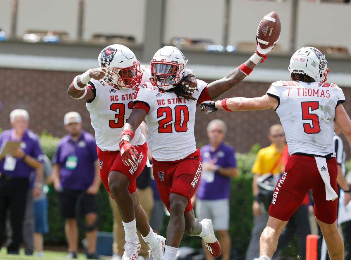 N.C. State’s Jordan Poole (33) celebrates with Sean Brown (20) after Brown recovered a blocked punt for a touchdown during the first half of N.C. State’s game against ECU at Dowdy-Ficklen Stadium in Greenville, N.C., Saturday, Sept. 3, 2022.