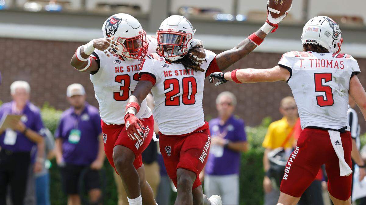 N.C. State’s Jordan Poole (33) celebrates with Sean Brown (20) after Brown recovered a blocked punt for a touchdown during the first half of N.C. State’s game against ECU at Dowdy-Ficklen Stadium in Greenville, N.C., Saturday, Sept. 3, 2022.