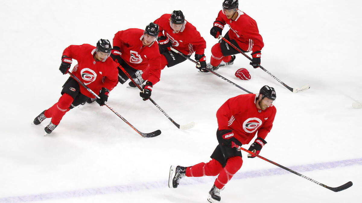 Players, including Carolina’s Jaccob Slavin (74), right bottom, and from left, Sebastian Aho (20), Andrei Svechnikov (37), Ryan Dzingel (18) and Ryan Suzuki (61), run drills during the Carolina Hurricanes’ practice at PNC Arena in Raleigh, N.C., Wednesday, July 22, 2020.