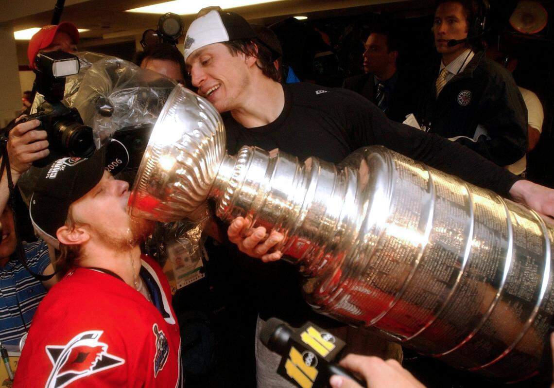 Carolina Hurricanes teammate Eric Staal drinks from the Stanley Cup being tipped by Rod Brind’Amour in the locker room after beating the Edmonton Oilers 3-1 on June 19, 2006 during game 7 of the Stanley Cup Final.