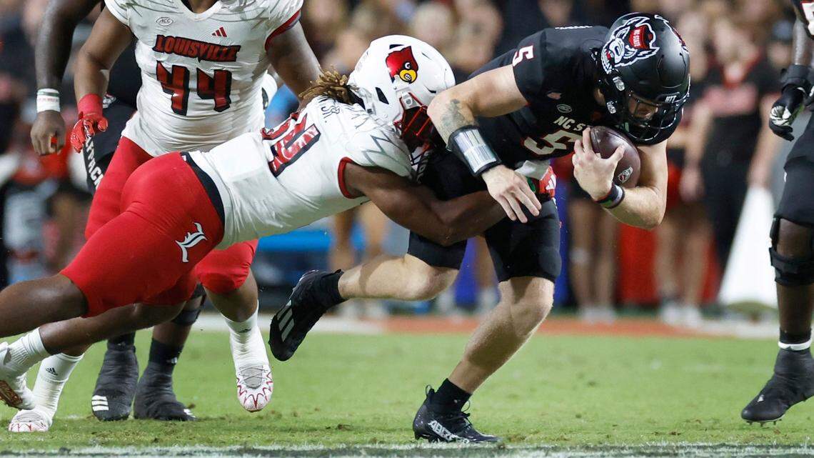 N.C. State quarterback Brennan Armstrong (5) is tackled by Louisville linebacker TJ Quinn (34) during the first half of N.C. State’s game against Louisville at Carter-Finley Stadium in Raleigh, N.C., Friday, Sept. 29, 2023.