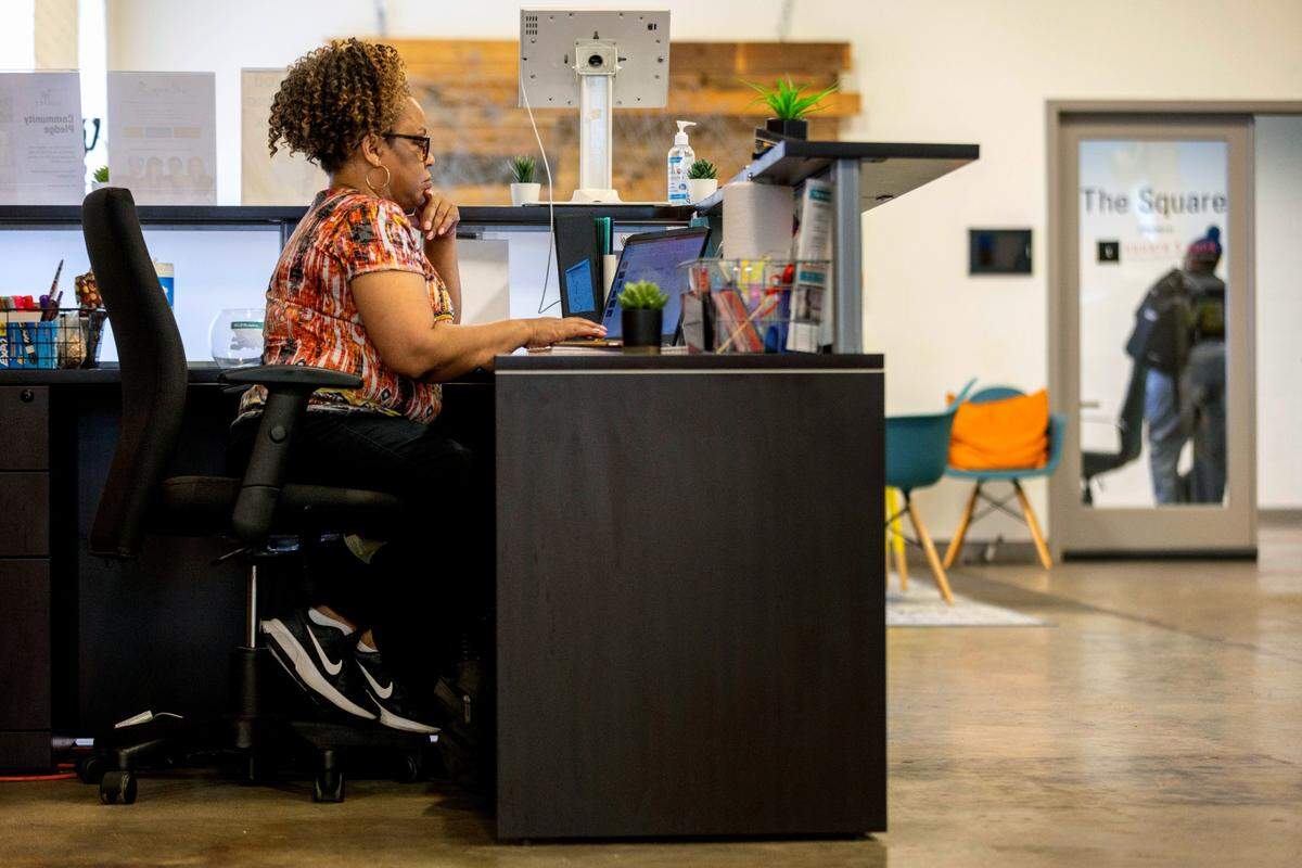 Dawn Taylor works the reception desk at ReCity Durham, a co-working space on Tuesday, April 26, 2022 in Durham, N.C. Taylor is working a second job to cope with the impact of the rising cost of living.