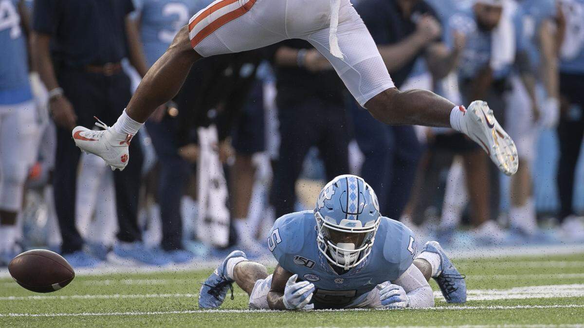 Clemson’s Isaiah Simmons (11) hurdles over North Carolina’s Dazz Newsome (5) who can’t contain a pass from quarterback Sam Howell late in the fourth quarter during the Tar Heels’ final drive of the game on Saturday, September 28, 2019 at Kenan Stadium in Chapel Hill, N.C.