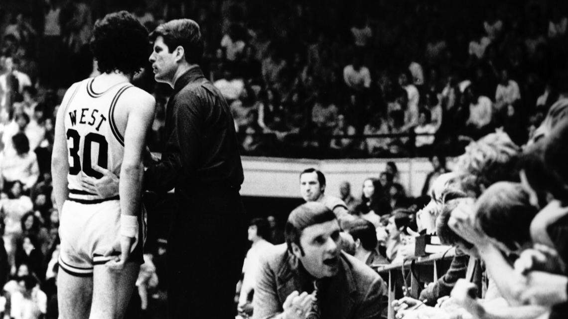 Duke coach Bucky Waters pulls aside Robbie West, who made the winning shot against heavily favored UNC in a 1972 matchup. In the foreground, assistant coach Hubie Brown is talking to the Blue Devils bench, as UNC coach Dean Smith stands in the background.