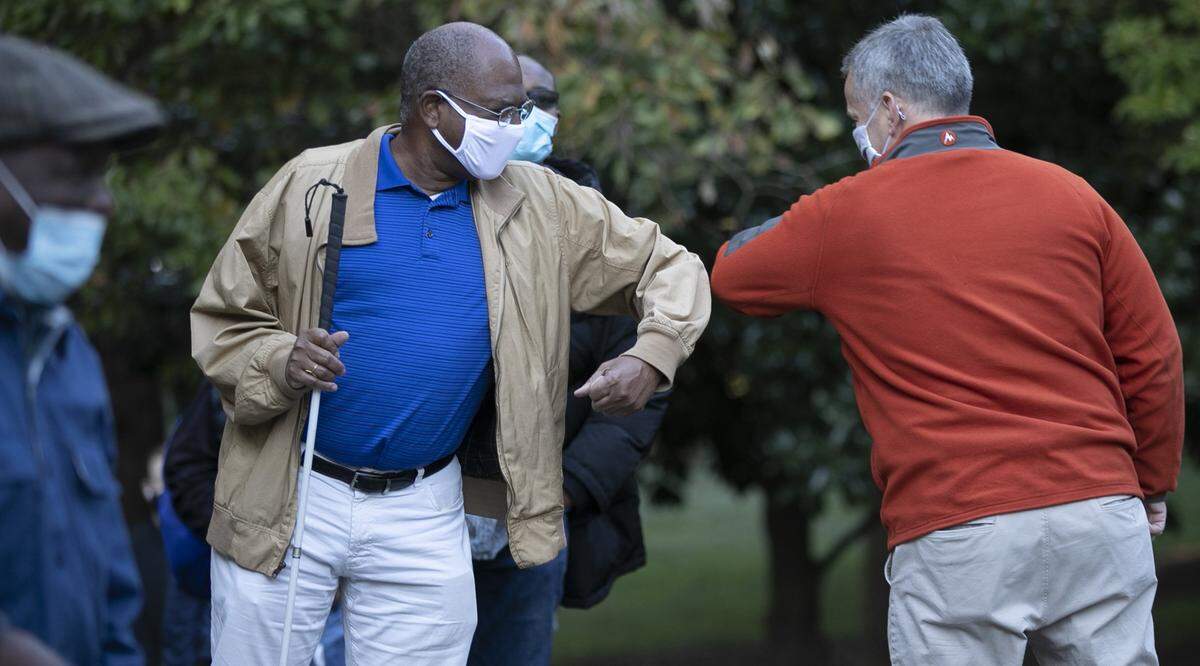 Attorney General Josh Stein elbow bumps Robert Parrish at the Roberts Park early voting site on Thursday morning, October 15, 2020 in Raleigh, N.C.