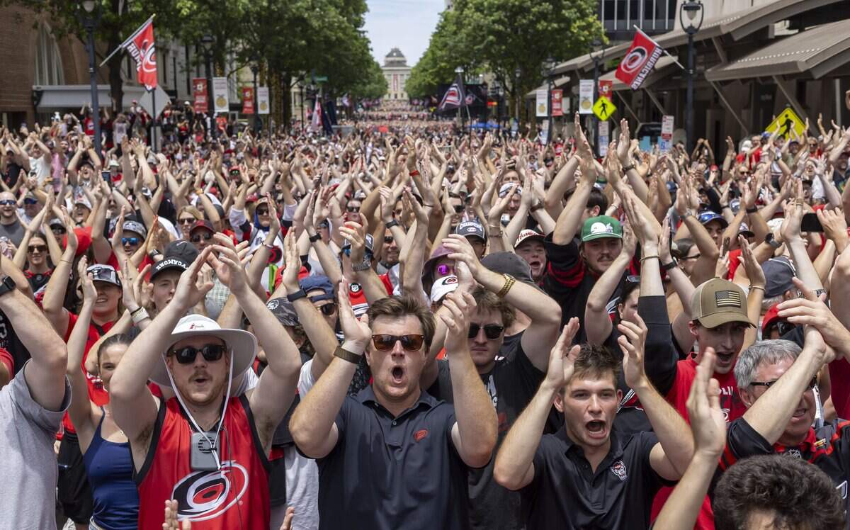 Cameron Anderson of Raleigh, center, takes part in the “Storm Surge” with fellow fans and  members of the Stanley Cup Champion Carolina Hurricanes, during their rally on City Plaza on Saturday, June 20, 2026 in Raleigh, NC.