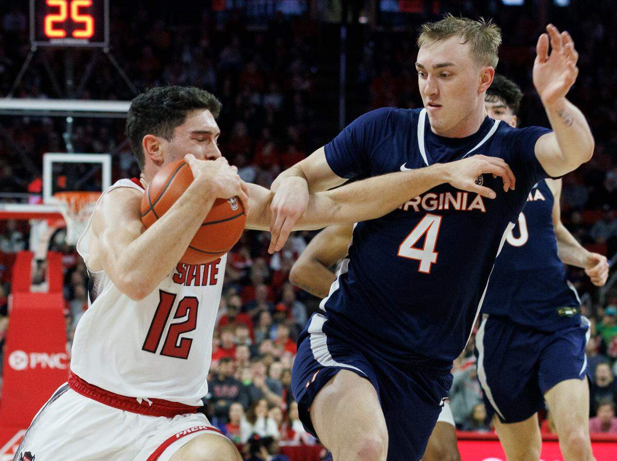 N.C. State’s Michael O’Connell drives past Virginia’s Andrew Rohde during the first half of the Wolfpack’s 76-60 win on Saturday, Jan. 6, 2024, at PNC Arena in Raleigh, N.C.