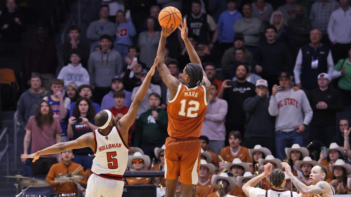 Texas’ Tramon Mark shoots over N.C. State’s Tre Holloman with seconds remaining in the Wolfpack’s 68-66 loss in the NCAA First Four on Tuesday, March 17, 2026, at the University of Dayton Arena in Dayton, Ohio. 