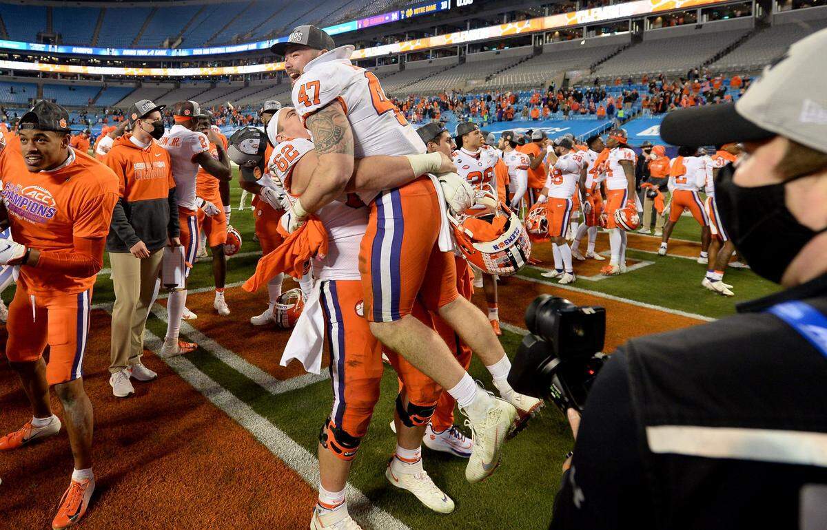 Clemson Tigers lineman Cade Stewart lifts linebacker James Skalski into the air following the teamÕs victory in the ACC Championship game. Clemson defeated Notre Dame 34-10 to win the championship at Bank of America Stadium in Charlotte, NC on Saturday, December 19, 2020.  
