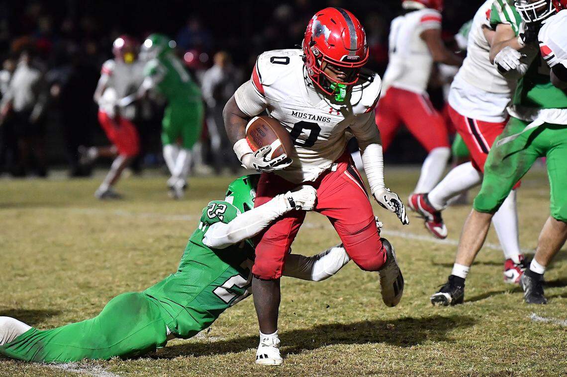 Middle Creek running back Jayden Spencer (0) runs for yardage against Cary's James Melvin (22) during the second  half. The Cary Imps and the Middle Creek Mustangs met in a conference football game in Cary, N.C. on October 24, 2025