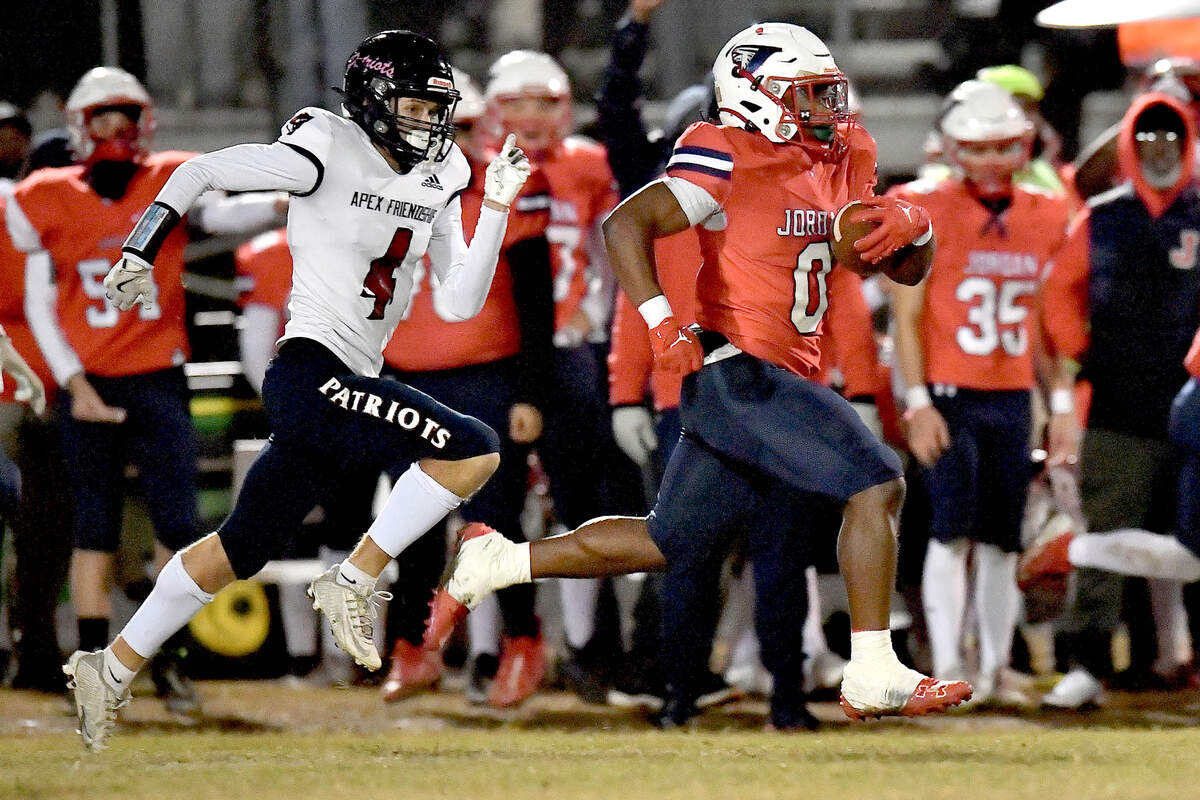 Jordan Amaeron Blue (0) runs for the long touchdown ahead of Apex Friendship’s Trevor Galvanek (4) during the first half. The Apex Friendship Patriots and the Durham Jordan Falcons met in the second round of the NCHSAA 4A playoffs in Durham, N.C. on November 22, 2024.