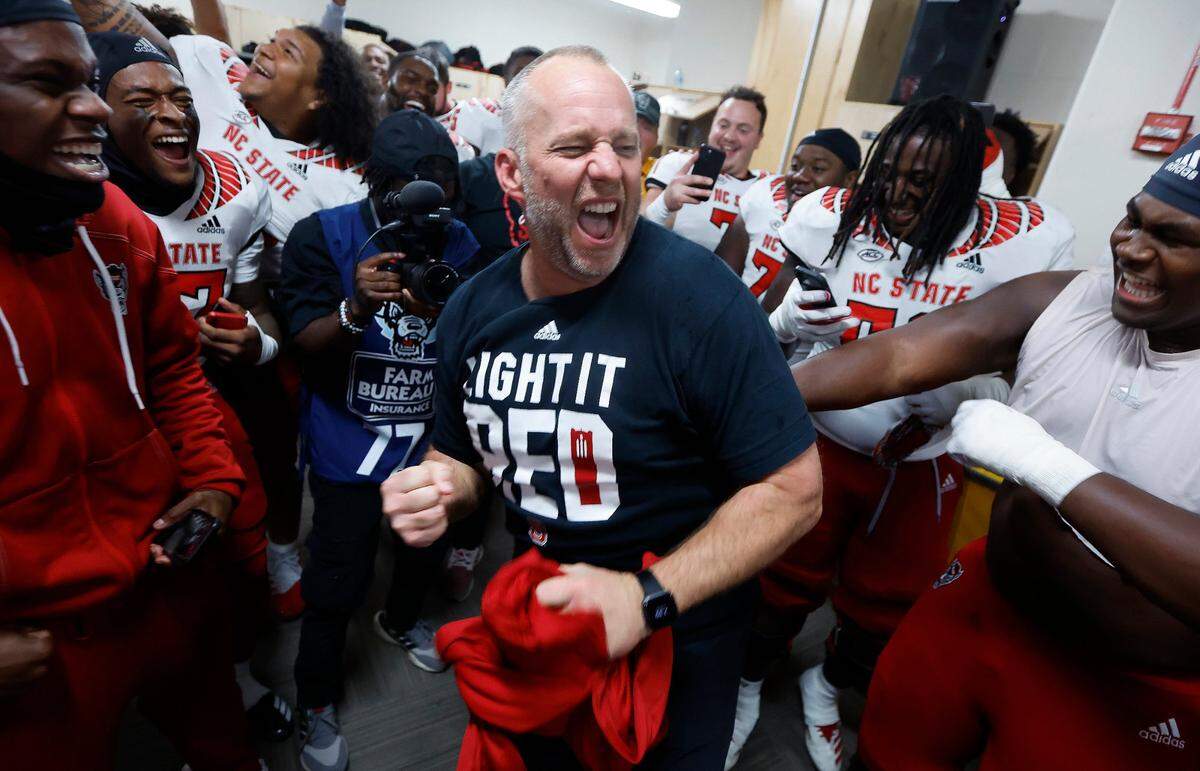 N.C. State head coach Dave Doeren celebrates in the locker room after N.C. State’s 30-27 overtime victory over UNC at Kenan Stadium in Chapel Hill, N.C., Friday, Nov. 25, 2022.