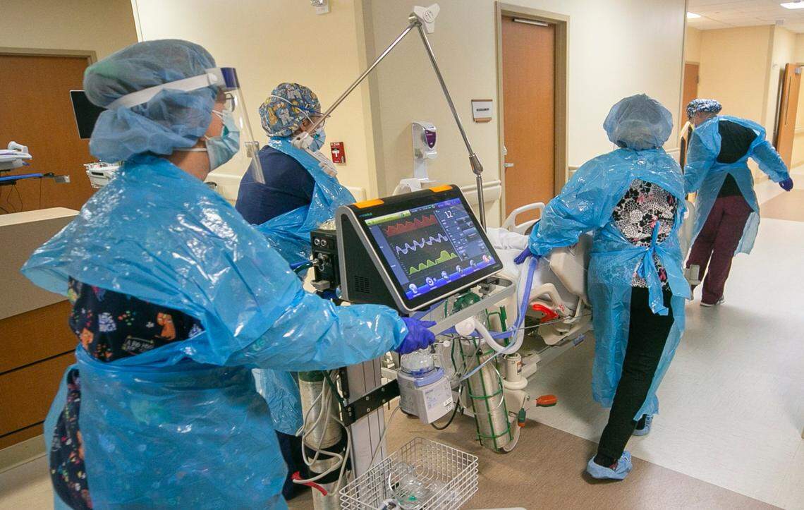 A team of nurses and respiratory therapists move a patient into the intensive care unit at Johnston UNC Health Care earlier in 2021. Hospitals are filling up once again as COVID cases are on the rise.