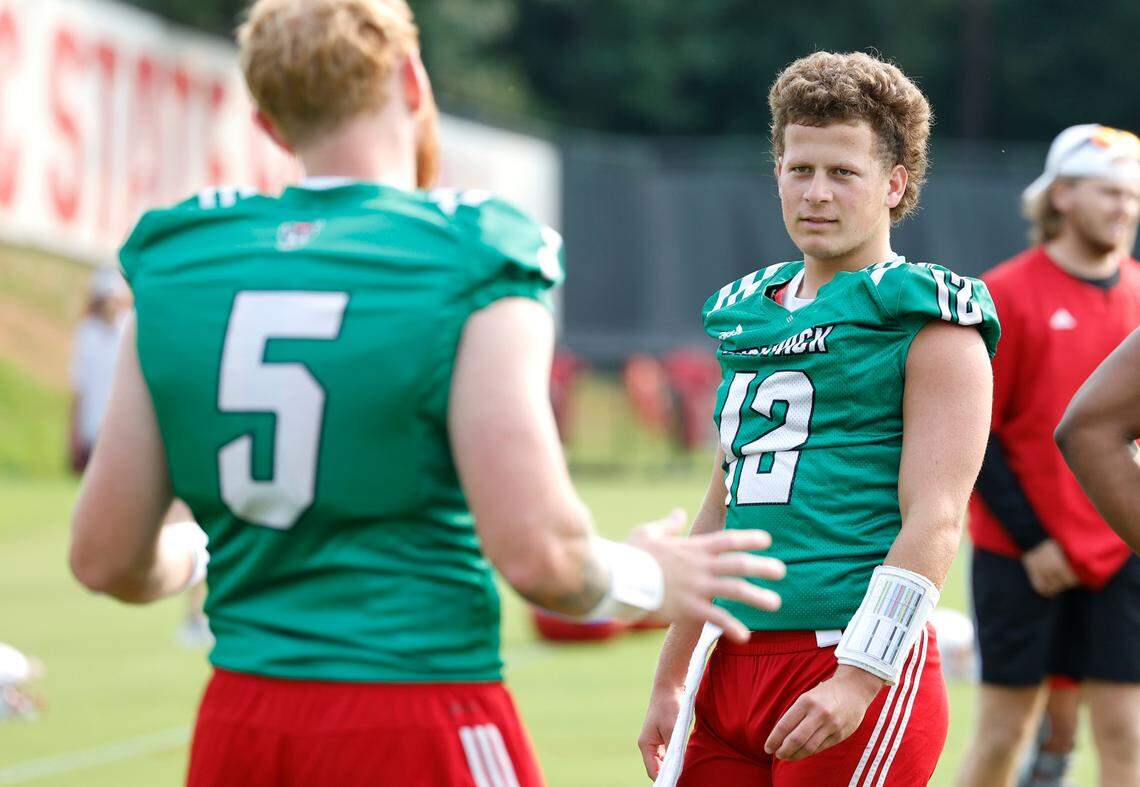 N.C. State quarterback Brennan Armstrong (5) talks with quarterback Lex Thomas (12) during the Wolfpack’s first fall practice in Raleigh, N.C., Wednesday, August 2, 2023.